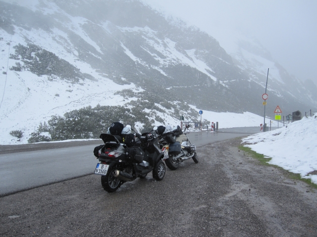 Bikes vor verschneiter, nebliger Passhöhe